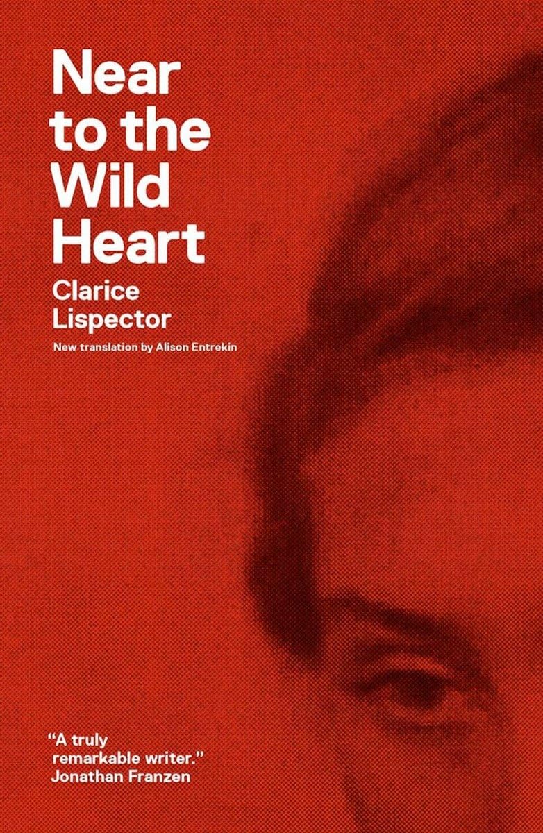 Book cover of Near to the Wild Heart by Clarice Lispector, featuring a striking red-orange background, a close-up portrait of a woman's face, and bold white typography displaying the book title and author's name. Customers seeking reader-friendly printed books throughout Bangladesh can shop for them through Bookish Wonderland, supported by delivery inside and outside Dhaka and clear print with strong binding.