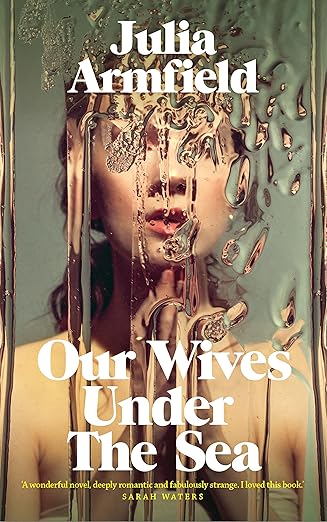 Book cover of 'Our Wives Under The Sea' by Julia Armfield with a woman's face and water theme. Bookish Wonderland provides a convenient way for readers across Bangladesh to order quality English books with customer-friendly ordering and delivery and clear print with strong binding.