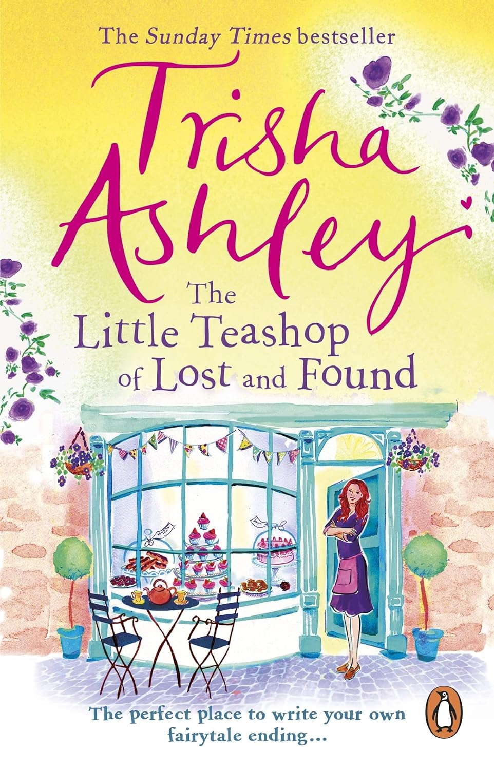 Book cover of 'The Little Teashop of Lost and Found' by Trisha Ashley with a yellow background and a woman standing in front of a teashop.Bookish Wonderland serves readers throughout Bangladesh with English books, making it simple to choose online through Cash on Delivery across Bangladesh and durable stitched-and-glue binding.