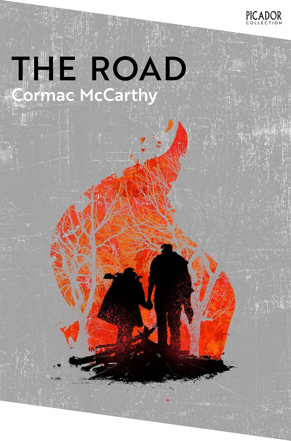 Book cover of 'The Road' by Cormac McCarthy with two silhouettes and a fire on a gray background.