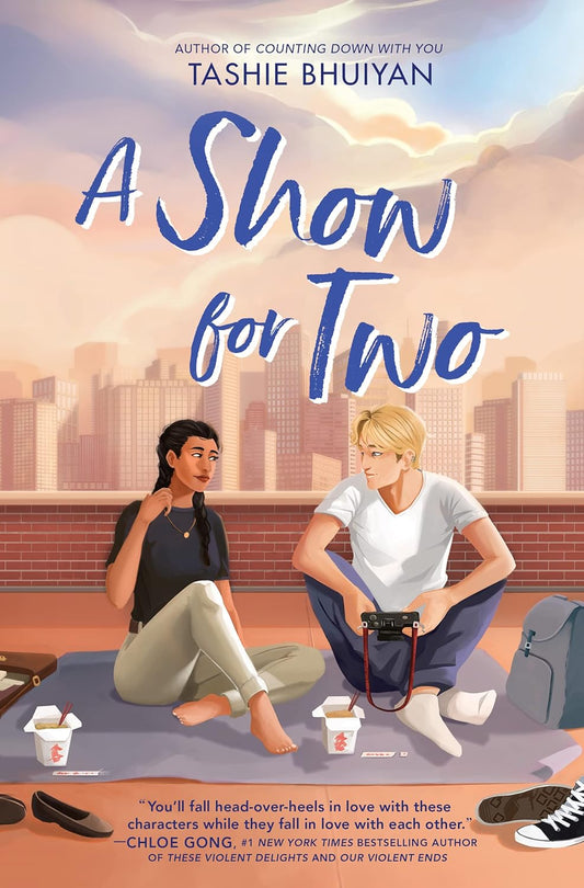 Book cover of 'A Show for Two' by Tashie Bhuiyan with two people sitting on a blanket in an urban setting. book in bd
