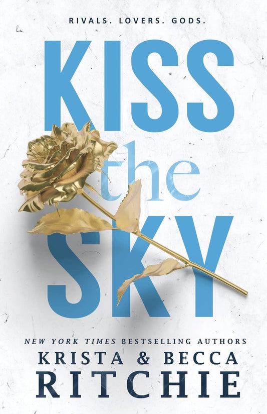 Cover of Kiss the Sky by Krista & Becca Ritchie featuring a gold metallic rose laid across bold blue title text on a textured white background. The romance novel cover includes the tagline Rivals. Lovers. Gods. and the authors' names at the bottom. Bookish Wonderland inspires readers across Bangladesh.