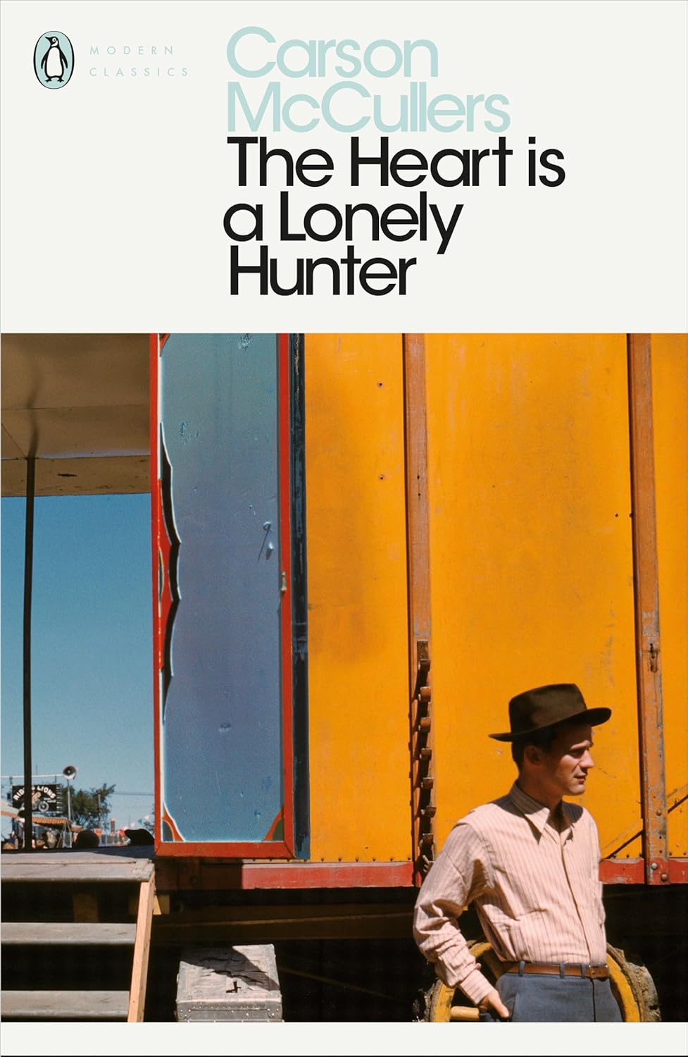 Book cover of 'The Heart is a Lonely Hunter' by Carson McCullers with a man standing next to a yellow truck.For customers across Bangladesh, Bookish Wonderland makes it easier to order books for study and leisure through convenient delivery across Bangladesh and comfortable cream paper and clear printing.