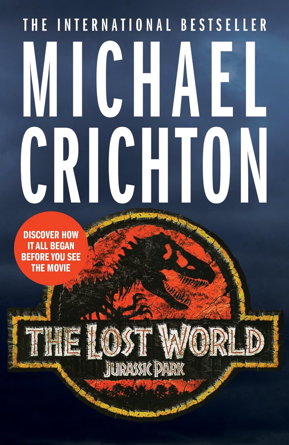 Book cover of 'The Lost World: Jurassic Park' by Michael Crichton with a dinosaur logo on a dark blue background. Customers seeking books for study and leisure throughout Bangladesh can order them through Bookish Wonderland, supported by Cash on Delivery across Bangladesh and high-quality stitched and glue binding.