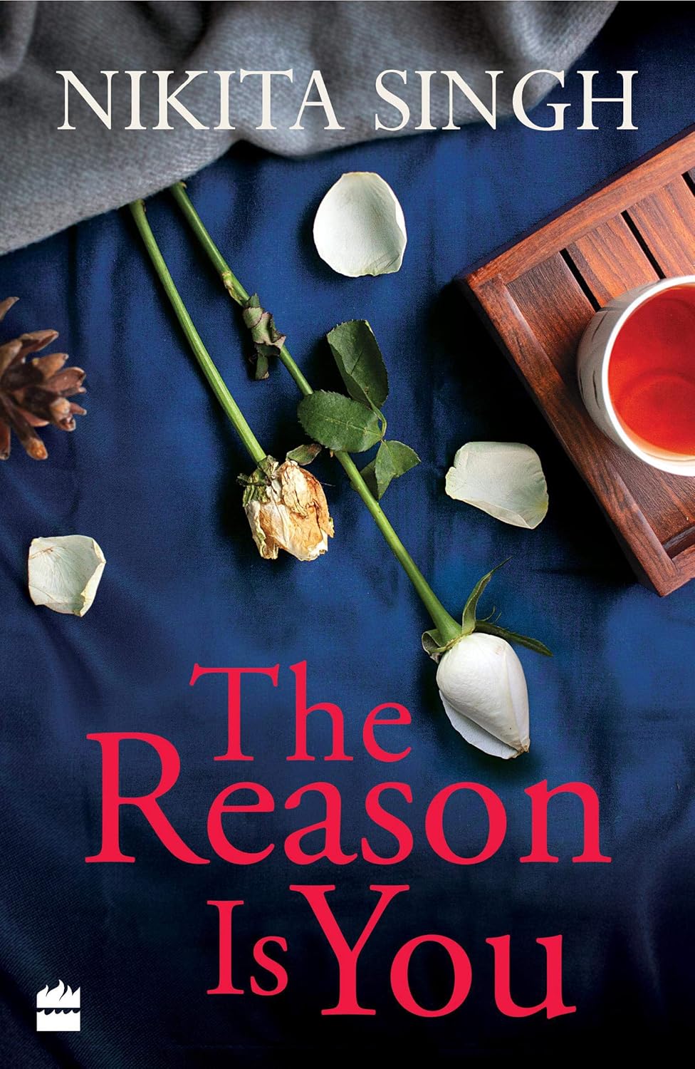 Book cover of 'The Reason Is You' by Nikita Singh with flowers and a teacup on a blue background. Book buyers throughout Bangladesh can choose quality English books from Bookish Wonderland, combining urgent delivery options in Dhaka with durable stitched-and-glue binding.