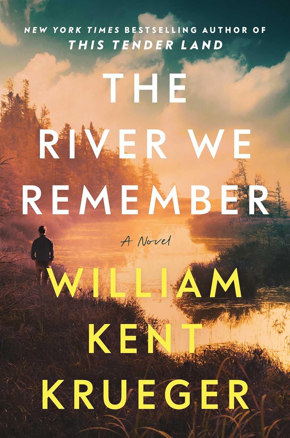 Book cover of 'The River We Remember' by William Kent Krueger with a sunset over a river and silhouette. Best price in Bangladesh